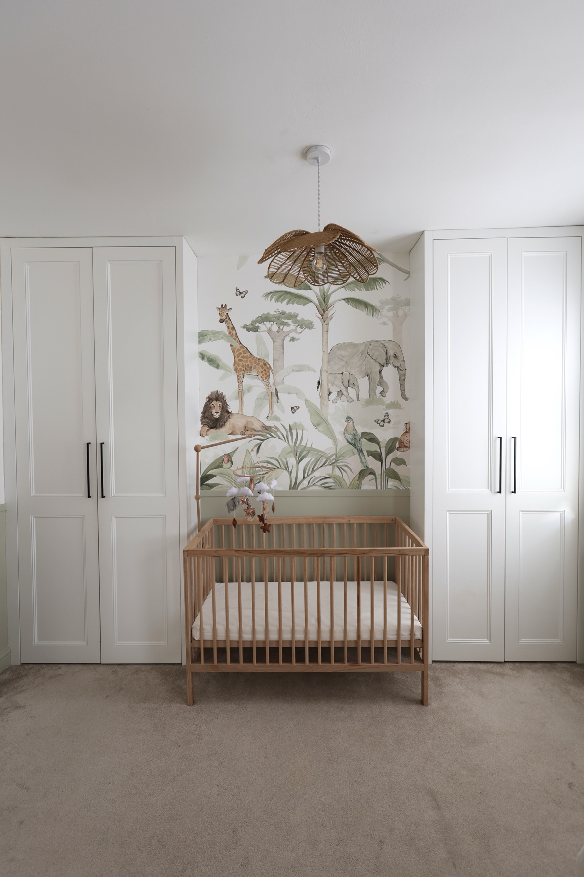 The cot and woodland mural in the baby room