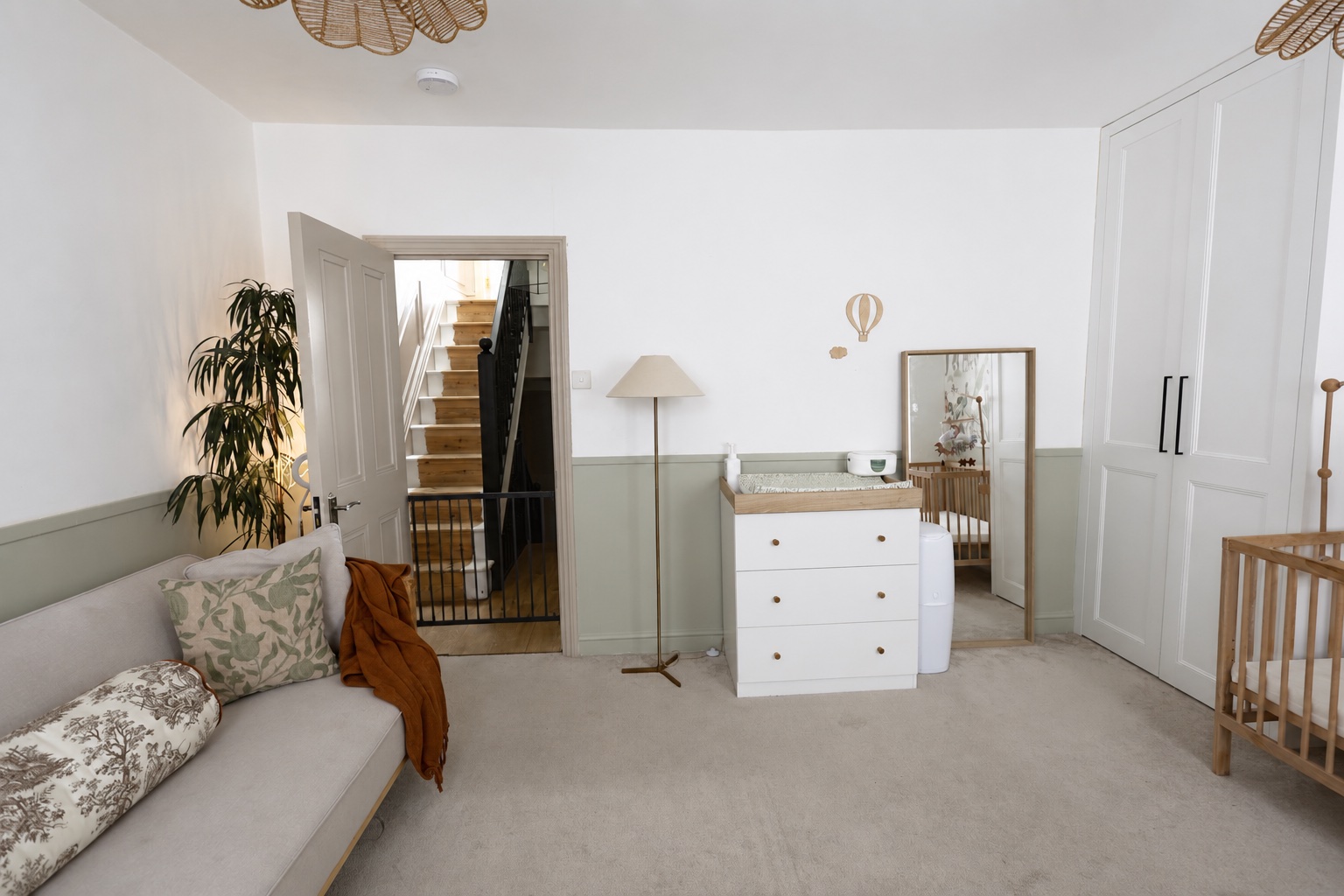 A wide view of the Root and Bloom baby room with seating, changing area and cot