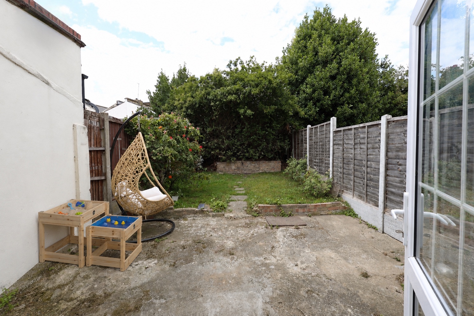 The Root and Bloom garden with outdoor play tables and a hanging chair